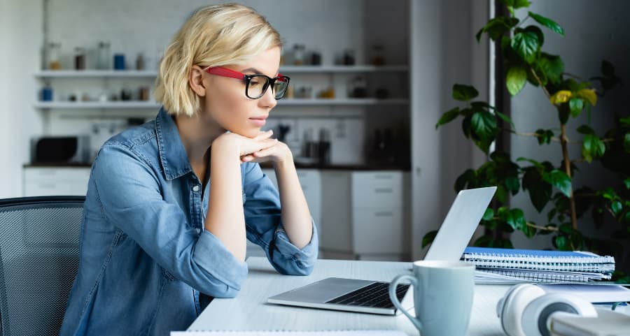 Individual using laptop computer in home office